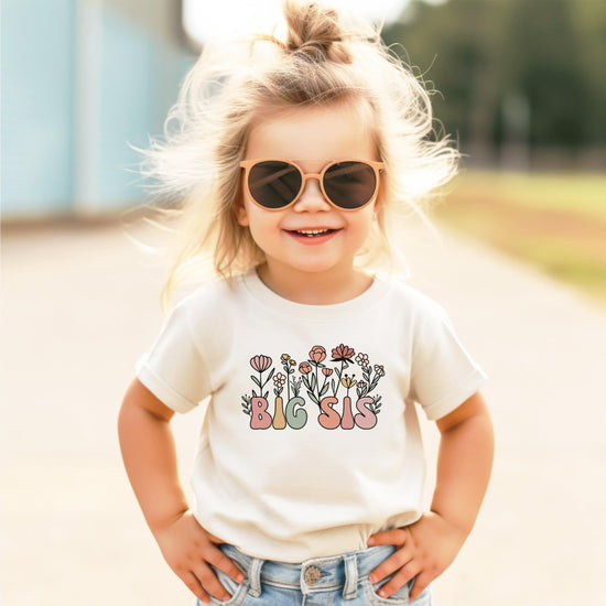 Front view of natural big sister toddler t-shirt laid flat showing full floral graphic