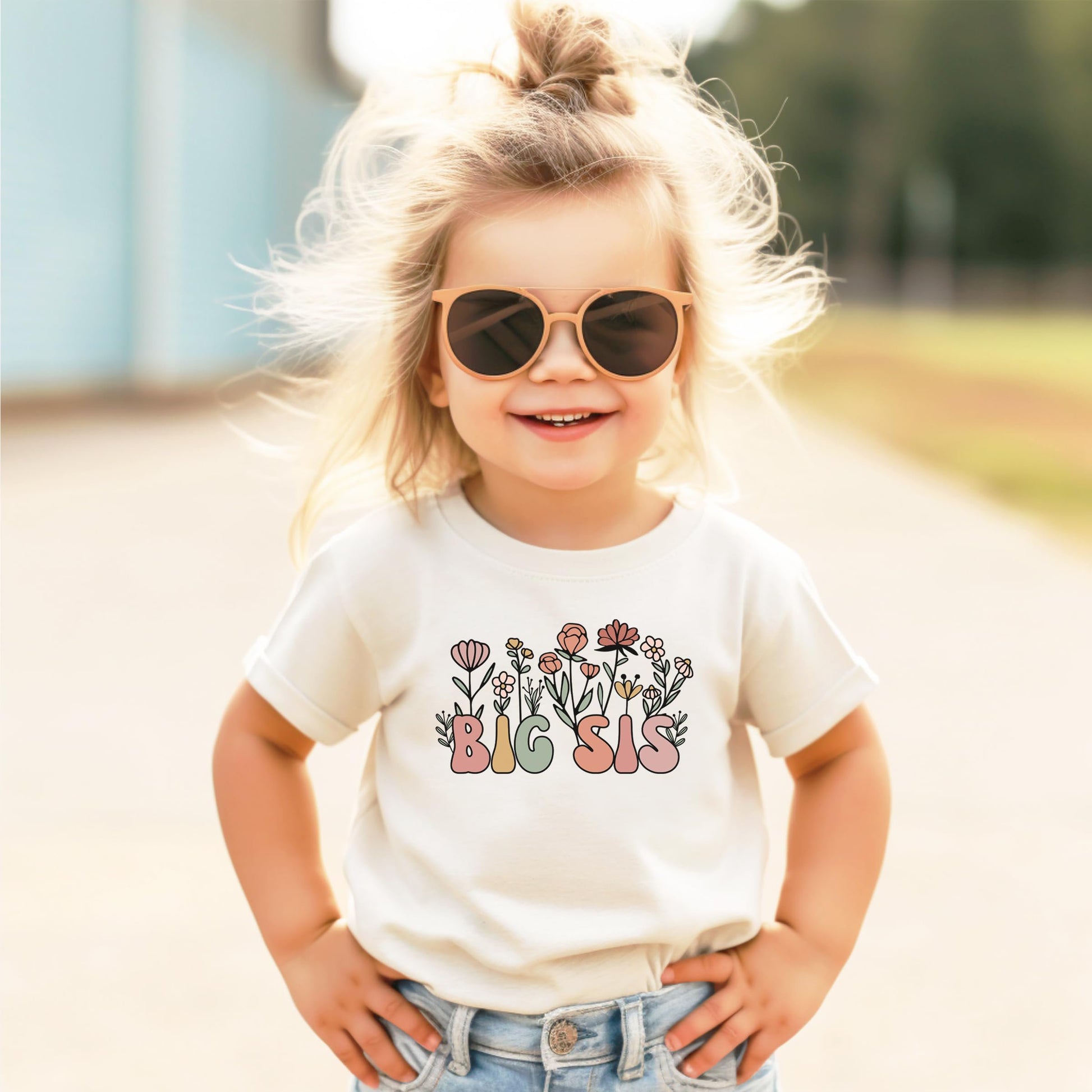 Front view of natural big sister toddler t-shirt laid flat showing full floral graphic