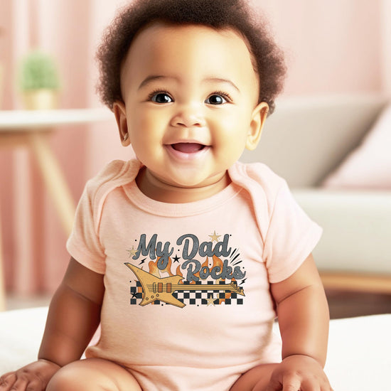My Dad Rocks infant bodysuit shown folded highlighting retro rockstar guitar graphic