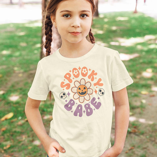 Youth girls Spooky Babe Halloween graphic tee laid flat showing daisy pumpkin design