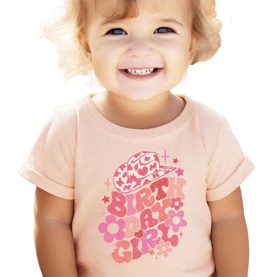 Flat lay of groovy cowgirl birthday girl shirt for baby and toddler girls
