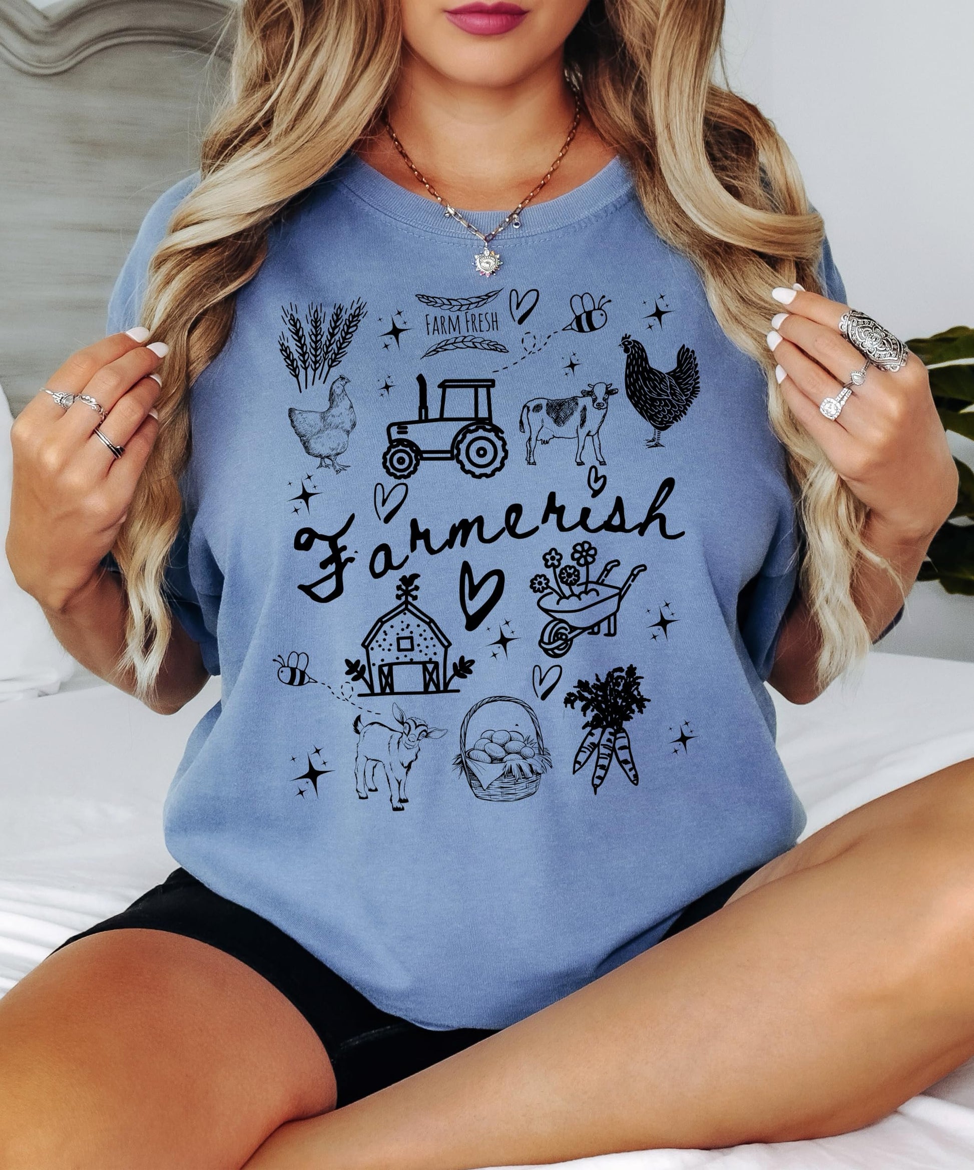 Detail shot of farm graphic tee print quality featuring cows, barns, carrots, and chickens