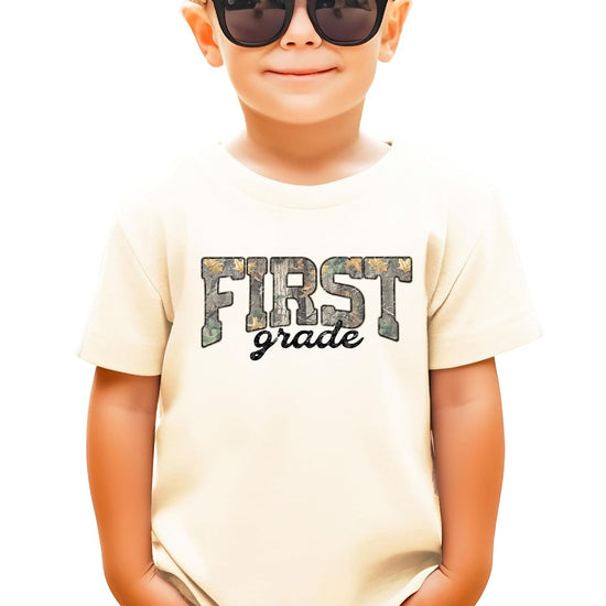 Flat lay of First Grade camouflage shirt in military green — kids unisex back to school tee