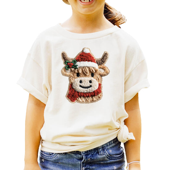 Close-up of ink-printed cow Christmas design on red youth graphic tee