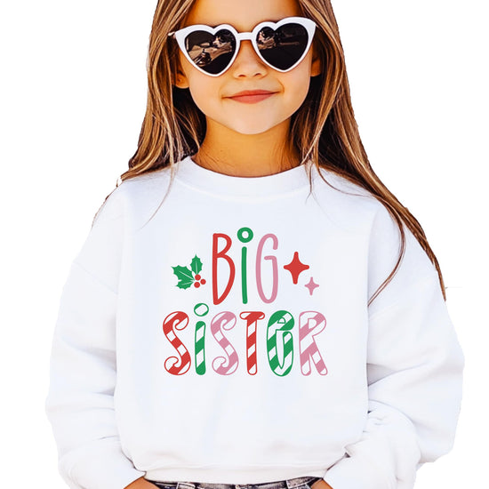 Kids white sweatshirt with candy cane stripe Big Sister lettering in red, green, and pink with holly and star accents