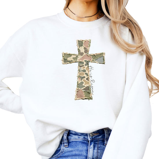 Women modeling camo He Is Risen Easter sweatshirt, casual faith-inspired pullover style