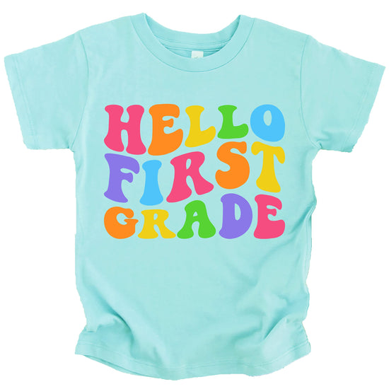 Front view of Hello 1st Grade purple shirt with colorful wavy text design