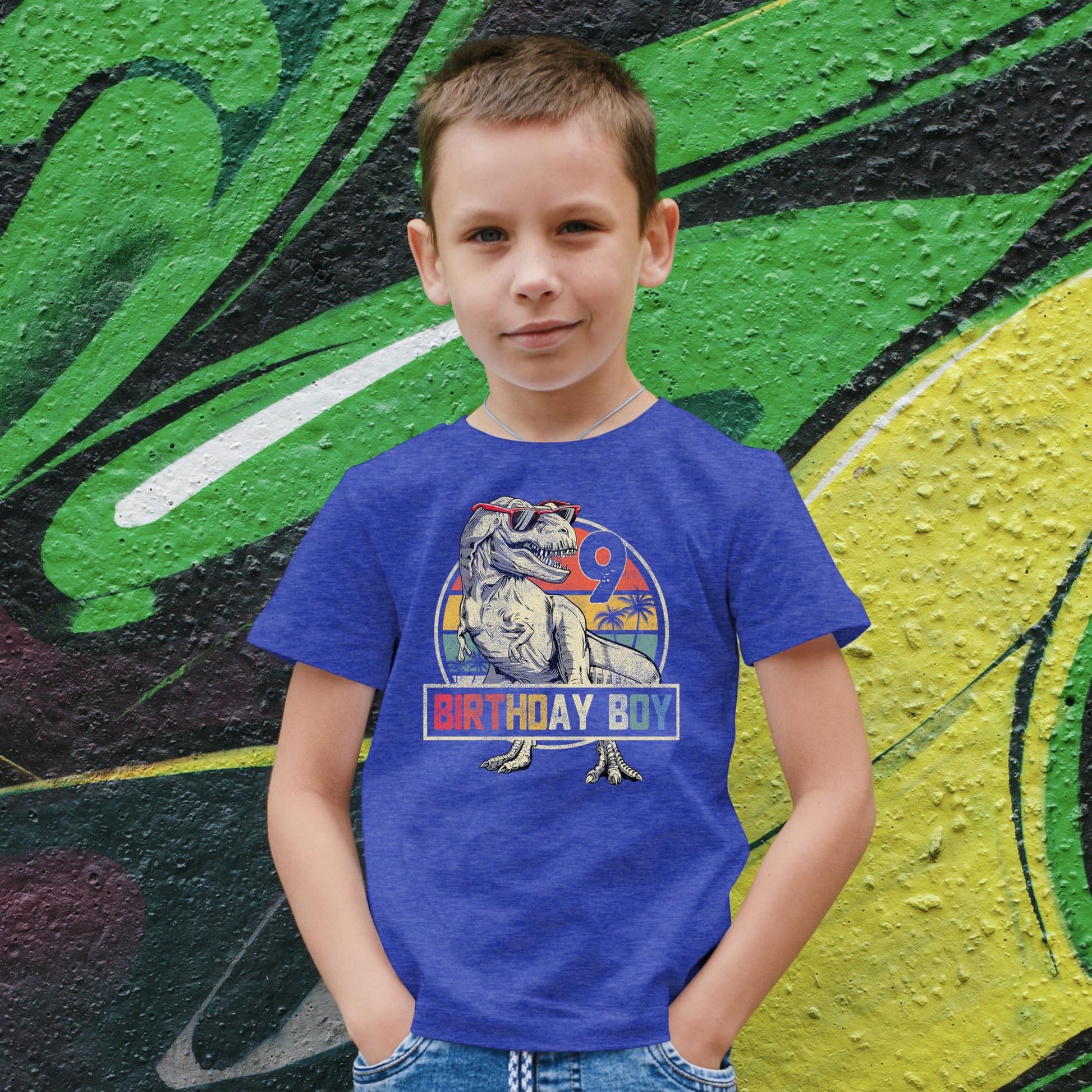 Close-up of T-Rex in sunglasses birthday boy print on kids graphic tee