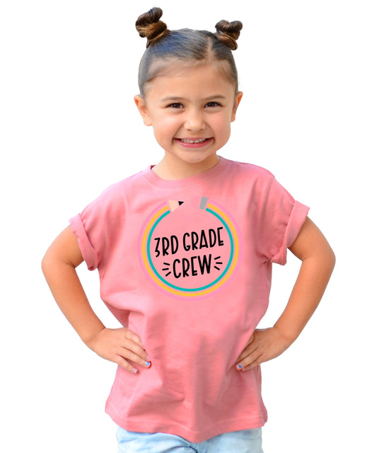 Front view of youth mauve 3rd Grade Crew pencil shirt on flat lay background