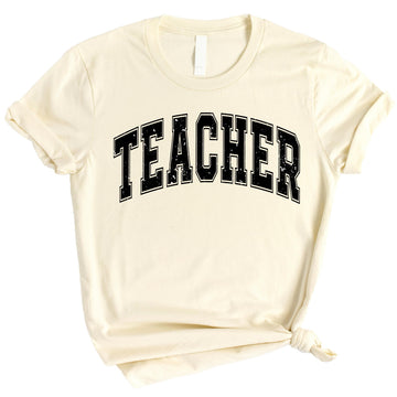 Black teacher varsity t-shirt with white collegiate lettering displayed on hanger
