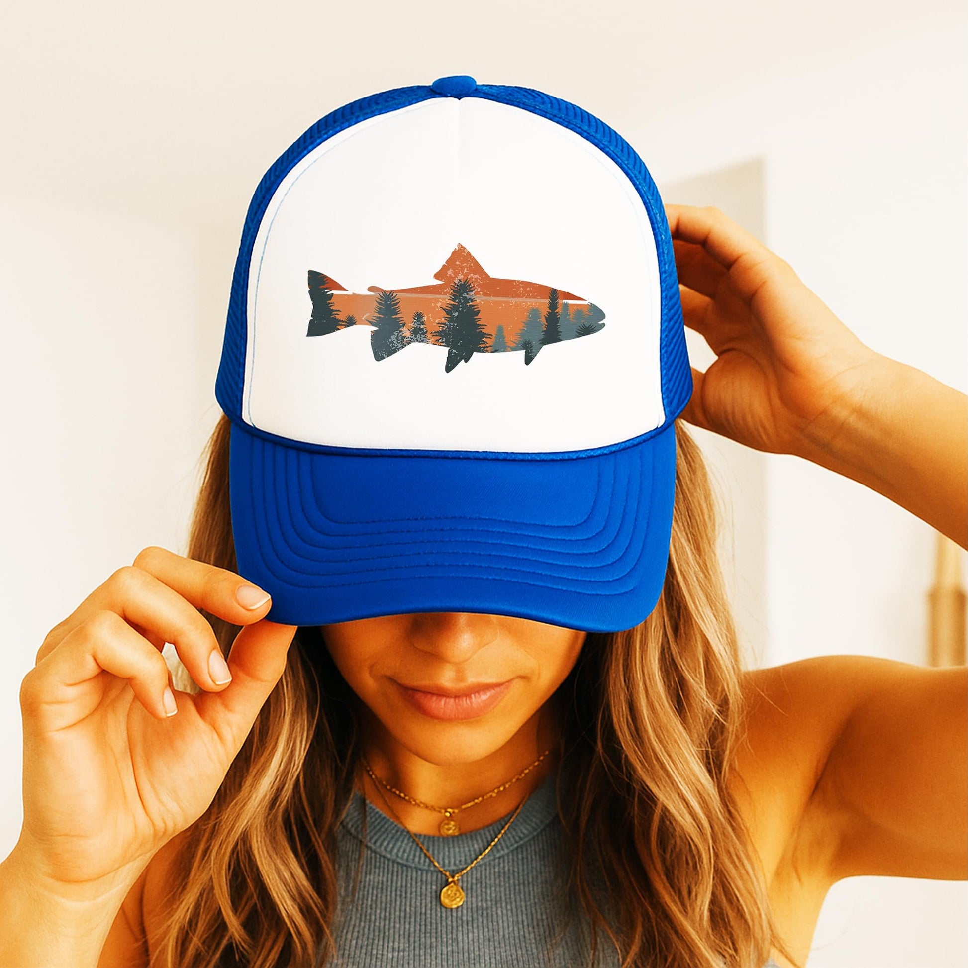 Woman wearing trout fishing sunset trucker hat - royal blue foam front snapback