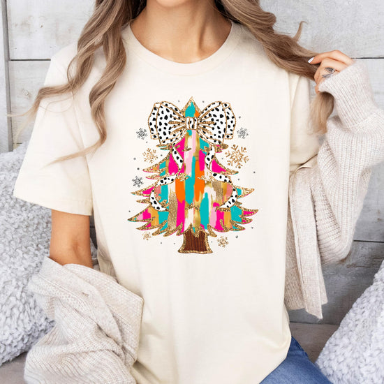 Detail shot of vibrant faux glitter Christmas tree Dalmatian bow shirt design on pink fabric