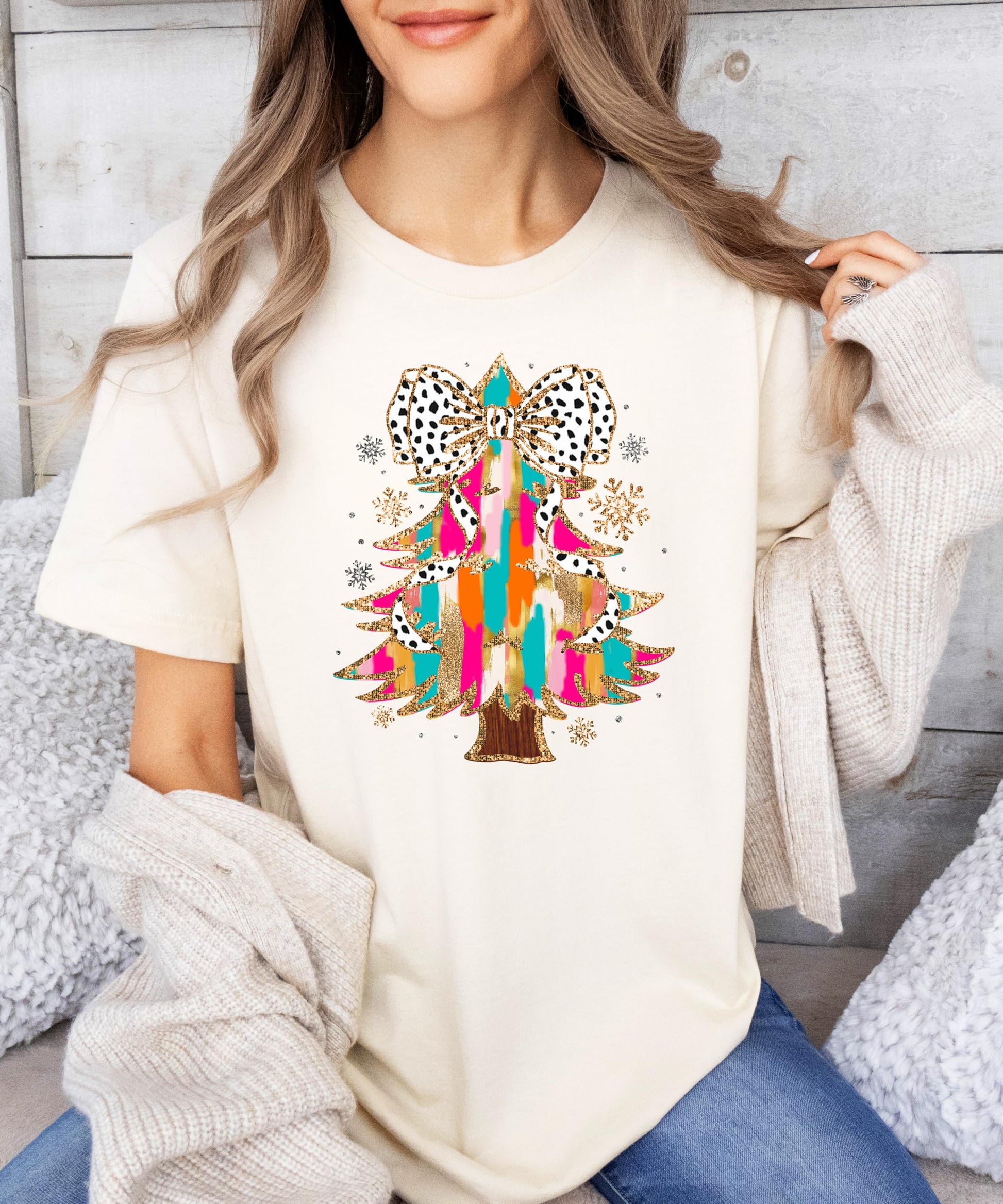 Detail shot of vibrant faux glitter Christmas tree Dalmatian bow shirt design on pink fabric