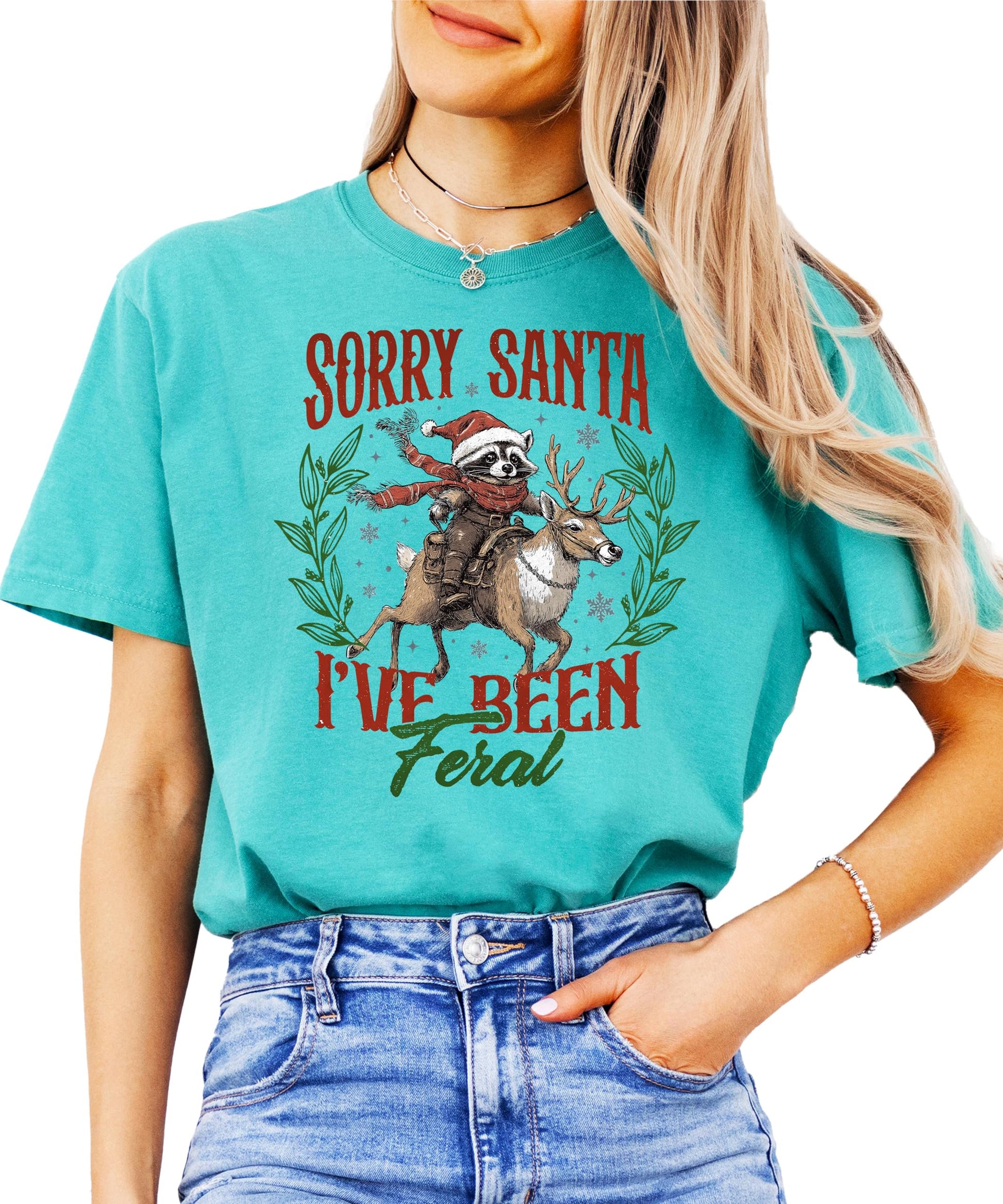 Close-up of mischievous raccoon holiday graphic print on seafoam green women's tee