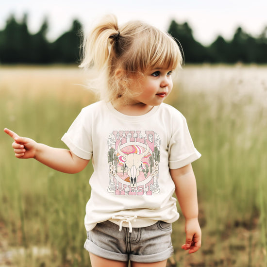 Toddler or young girl wearing pink Western cowgirl graphic tee with desert theme by Olive Loves Apple