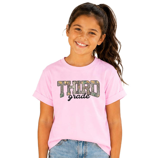 Siblings wearing matching grade-level camo tees from Olive Loves Apple back-to-school collection