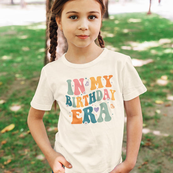 Detail shot of soft peach youth birthday shirt with trendy 'In My Birthday Era' graphic print