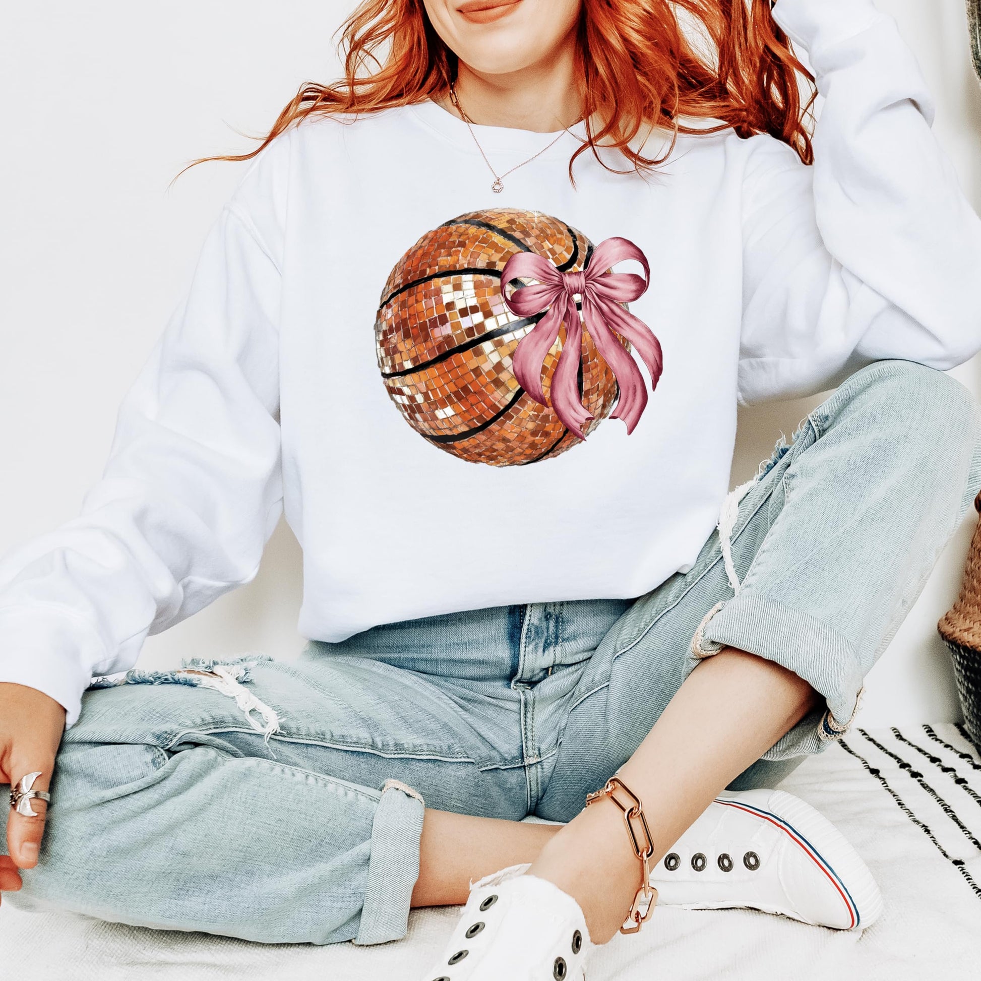Side or lifestyle view of women's gray disco basketball sweatshirt with pink bow design