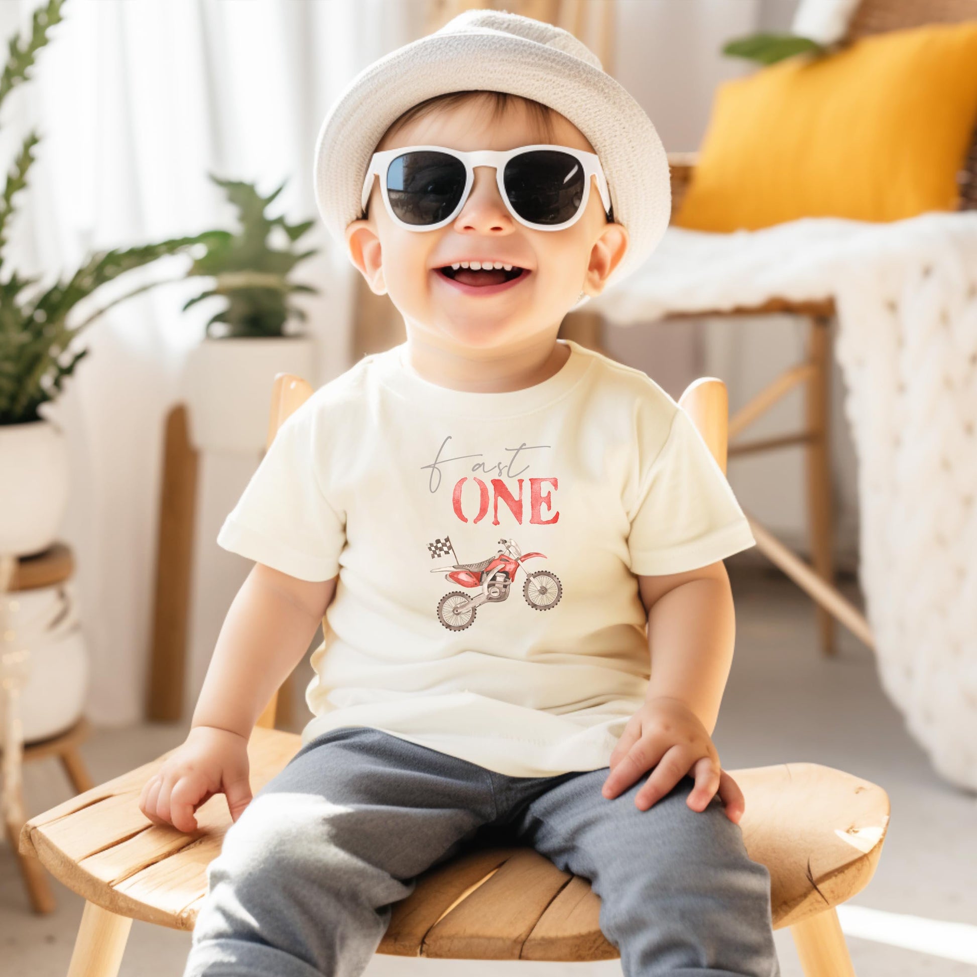 Toddler wearing Fast One dirt bike first birthday shirt in natural color