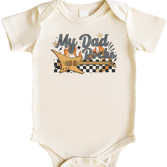 Baby wearing My Dad Rocks graphic bodysuit laid flat showing full front design