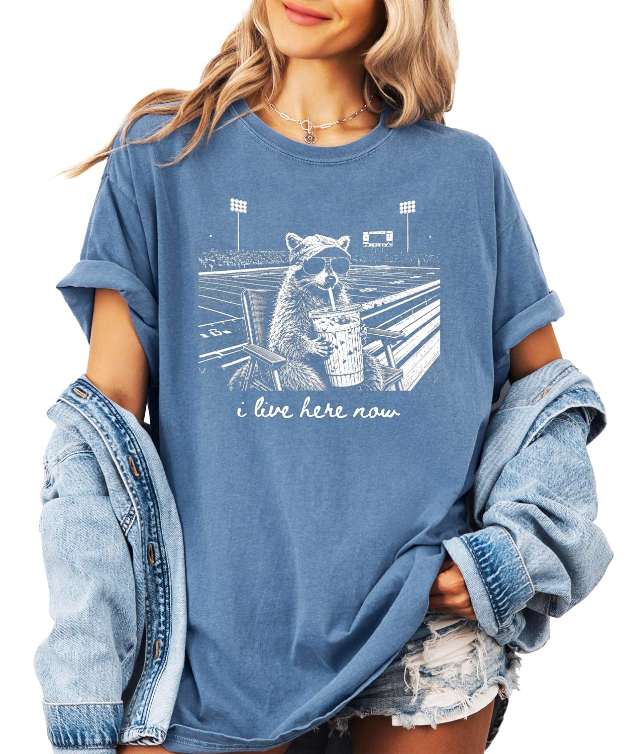 I Live Here Now funny raccoon football mom graphic tee in garment-dyed Comfort Colors, front view