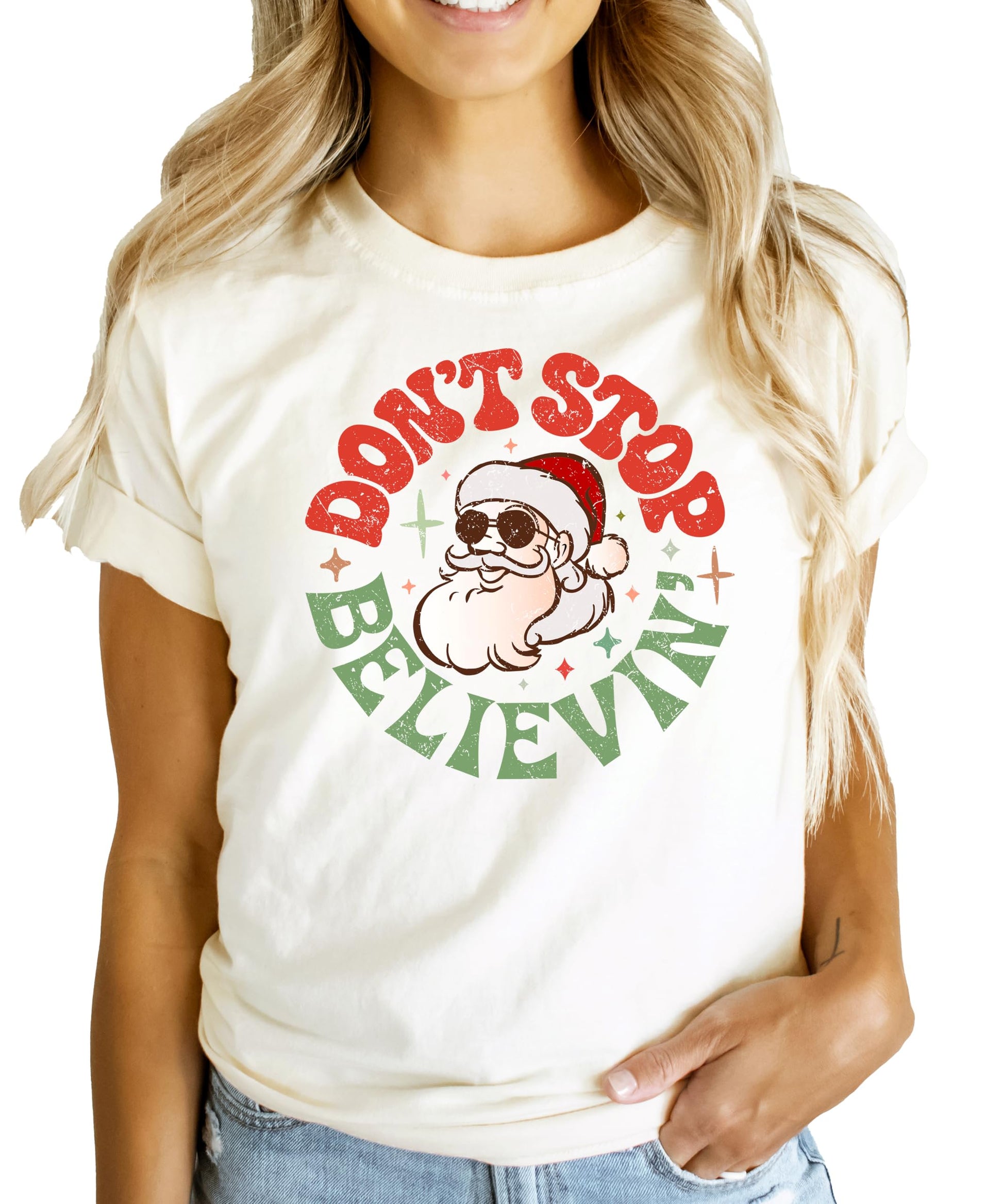 Front view of festive Don't Stop Believing Santa holiday shirt for women