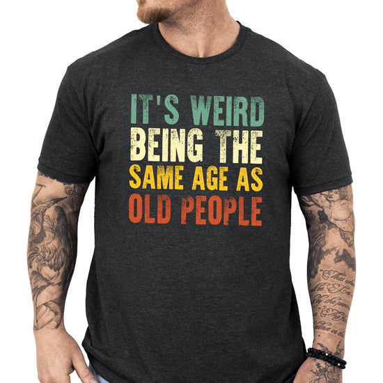 Dark gray heather men's graphic tee with funny 'It's Weird Being The Same Age As Old People' text print