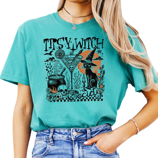 Tipsy Witch Society Halloween graphic tee featuring a witchy black cat, cocktail glass, and cauldron design on a black shirt
