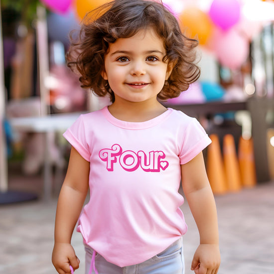 Little girl wearing pink fourth birthday graphic tee at party