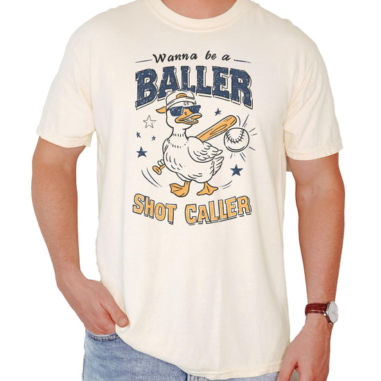 Close-up view of duck baseball graphic design on cream colored unisex t-shirt