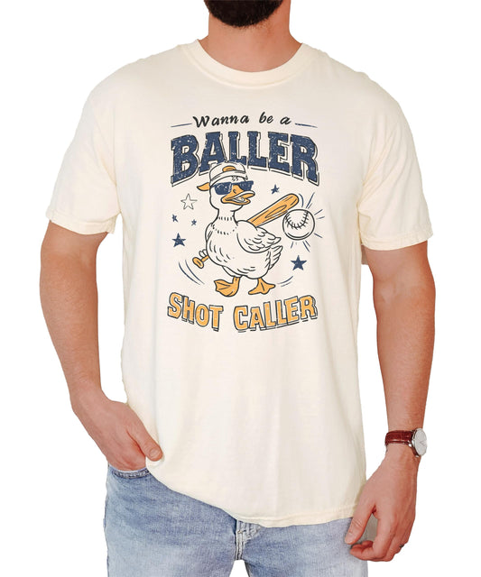 Close-up view of duck baseball graphic design on cream colored unisex t-shirt