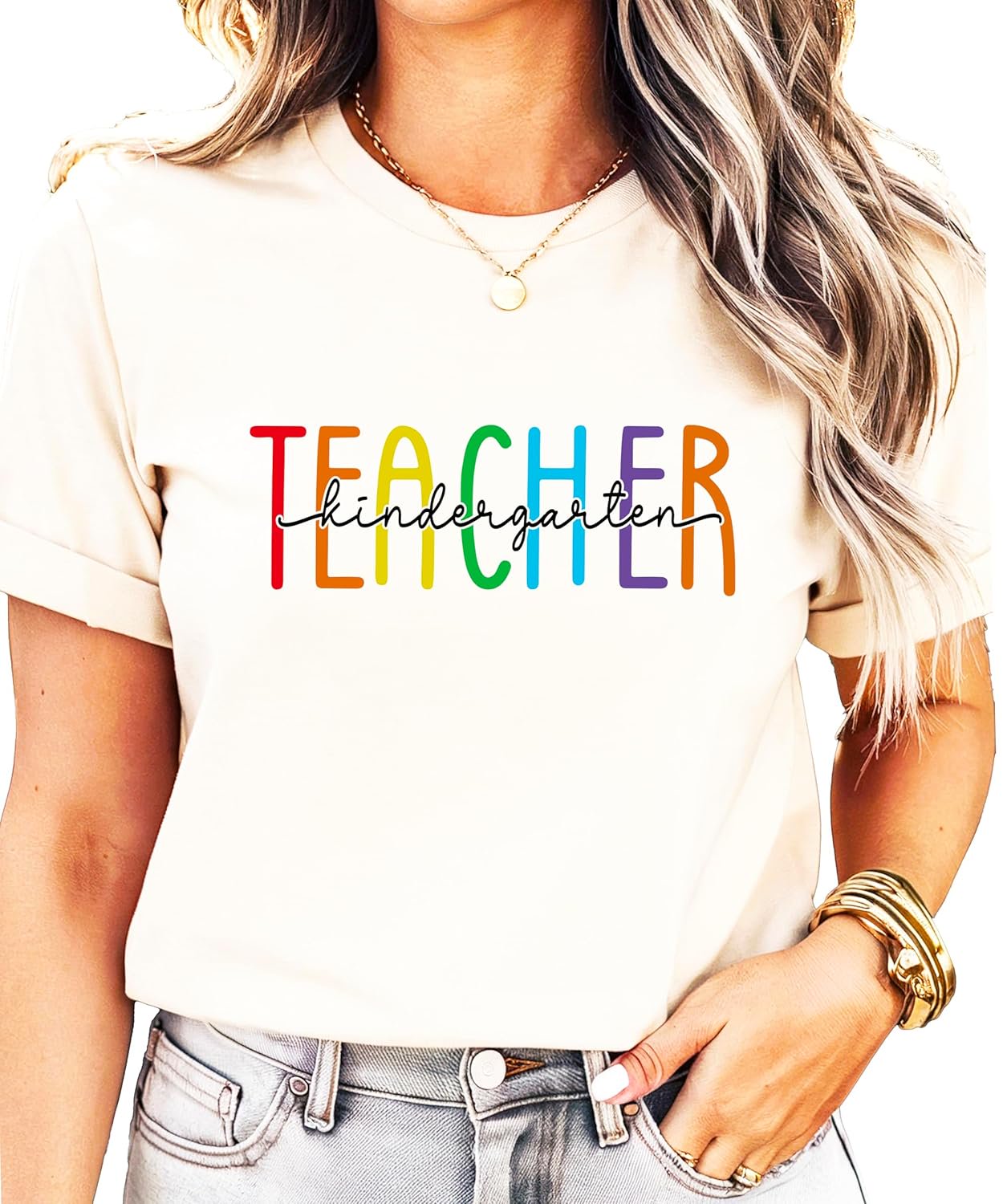 Women's pink kindergarten teacher shirt with bold rainbow TEACHER letters and hand-lettered script overlay