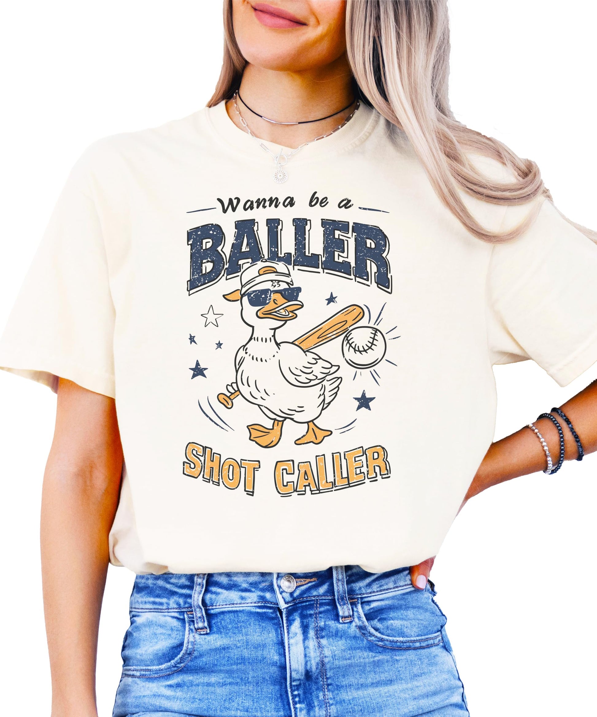 Ivory baseball shirt with "Wanna Be A Baller Shot Caller" text and cartoon duck graphic design