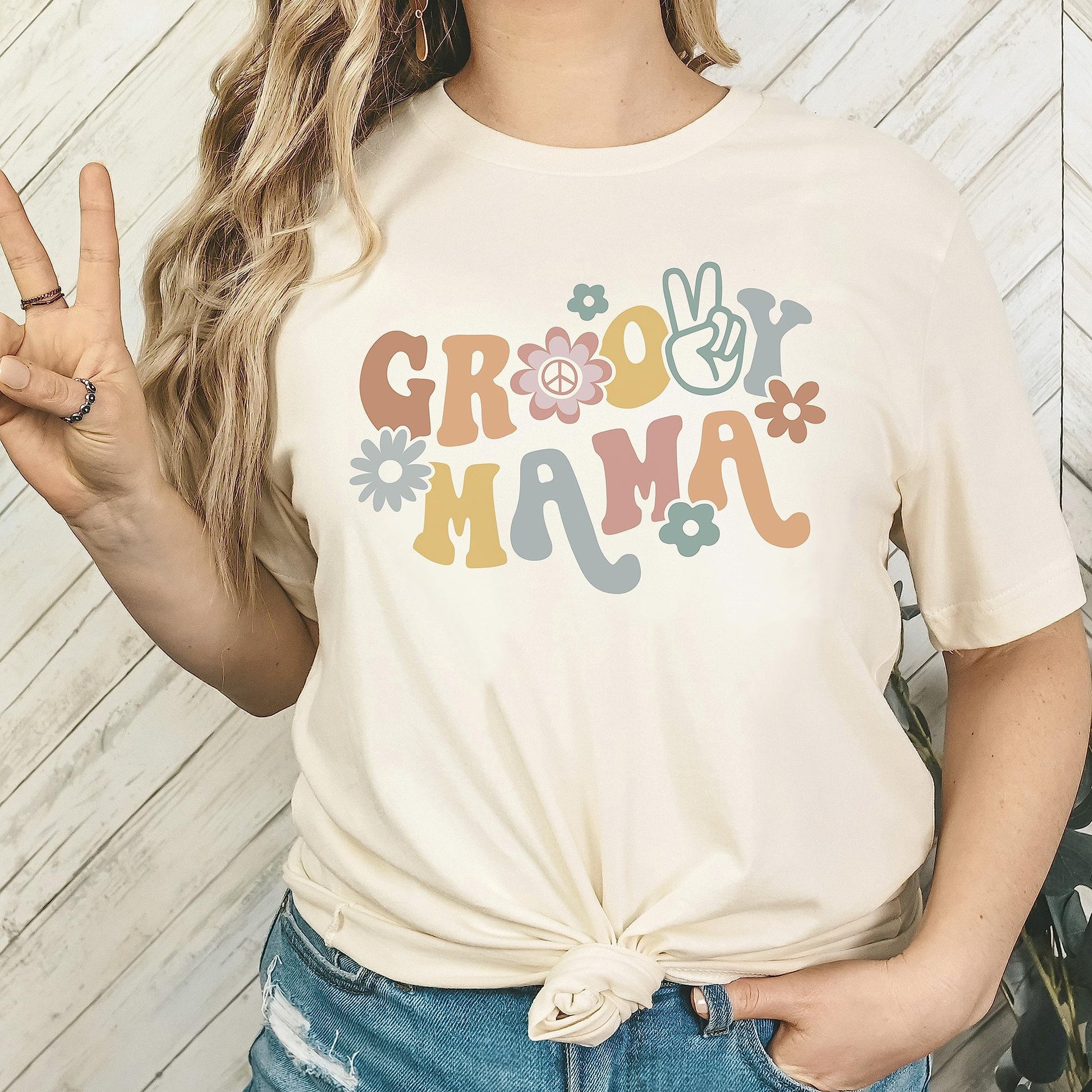 Close-up of Groovy Mom shirt print — vibrant retro typography on natural-tone women's tee