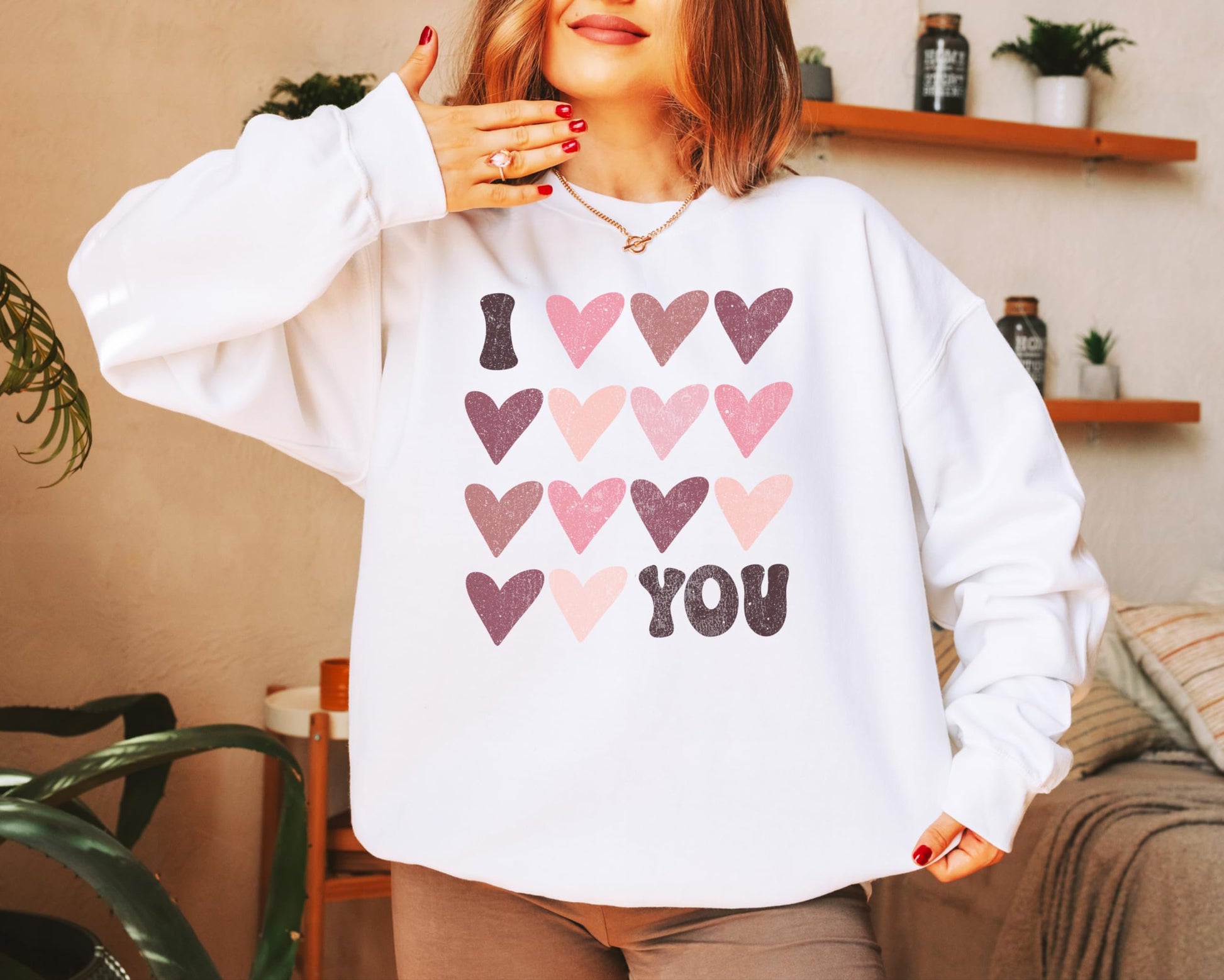 Lifestyle flat lay of Olive Loves Apple Galentine's Day sweatshirt featuring I Love You graphic design