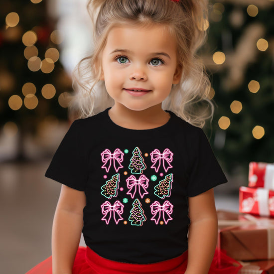 Flat lay of black women's holiday tee showcasing electric neon Christmas trees and gift bows print