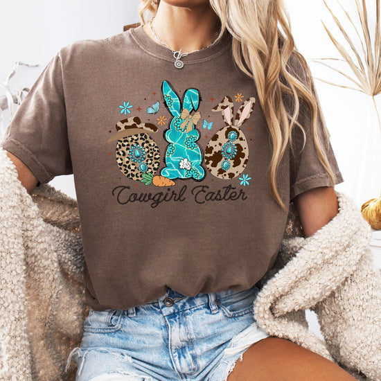 Close-up of cowgirl Easter graphic tee showing rope-style lettering and cow print hat bunny illustration