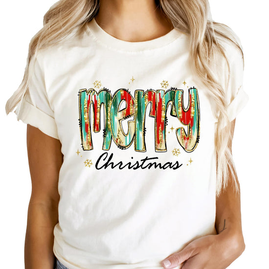 Close-up of vibrant watercolor Merry Christmas graphic print on peach holiday shirt
