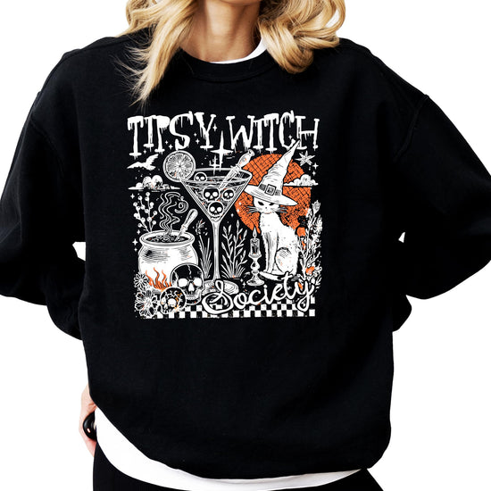 Flat lay of black women's Halloween crewneck sweatshirt with Tipsy Witch Society funny graphic tee design