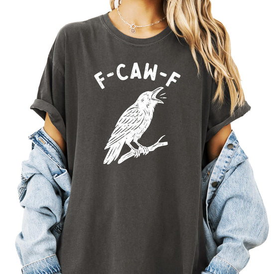 Flat lay of seafoam adult Halloween graphic tee with humorous black crow F-Caw-F design