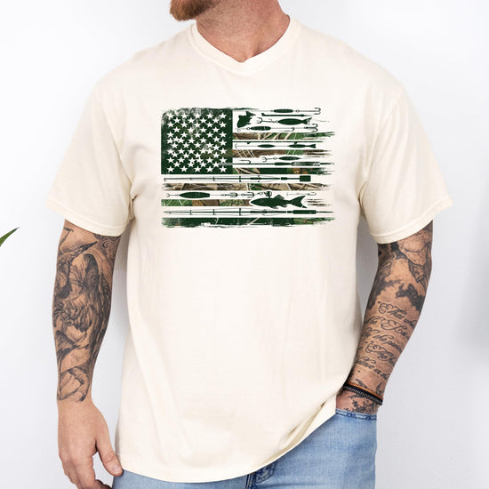 Front view of patriotic fishing graphic tee on model, ivory shirt with American flag and fishing lure print