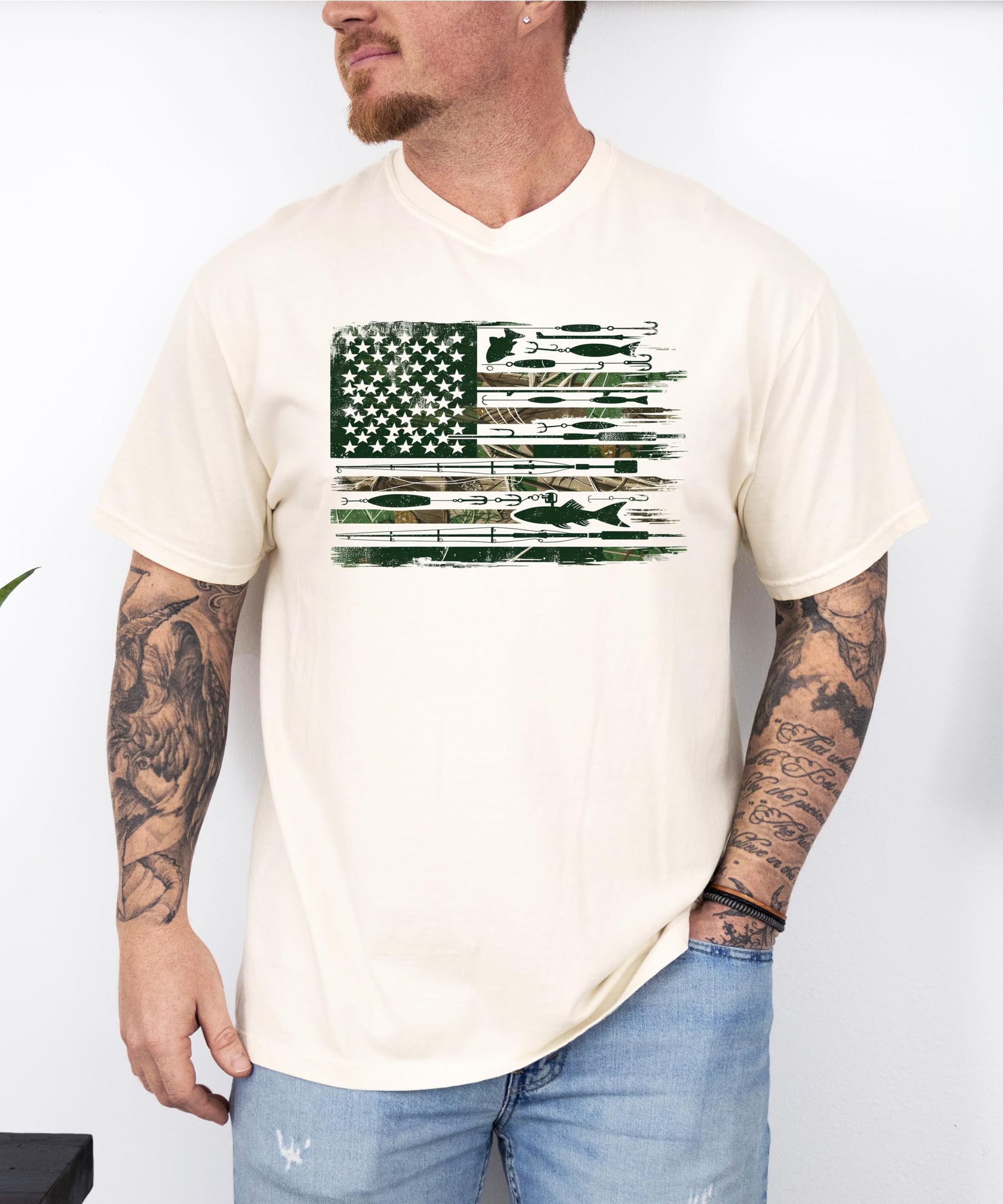 Front view of patriotic fishing graphic tee on model, ivory shirt with American flag and fishing lure print