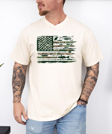 Front view of patriotic fishing graphic tee on model, ivory shirt with American flag and fishing lure print