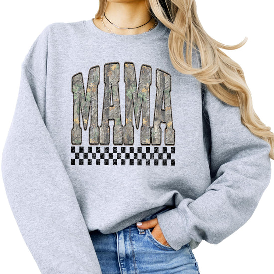 Close-up of bold MAMA lettering in distressed camouflage print on black crewneck sweatshirt