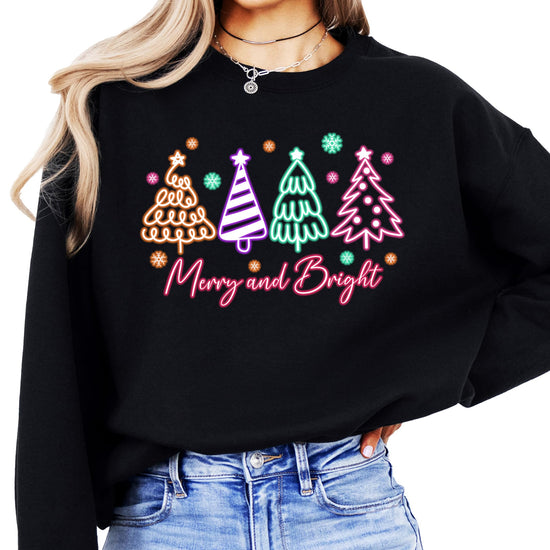 Women's black pullover sweatshirt with electric neon Christmas trees and Merry and Bright graphic print