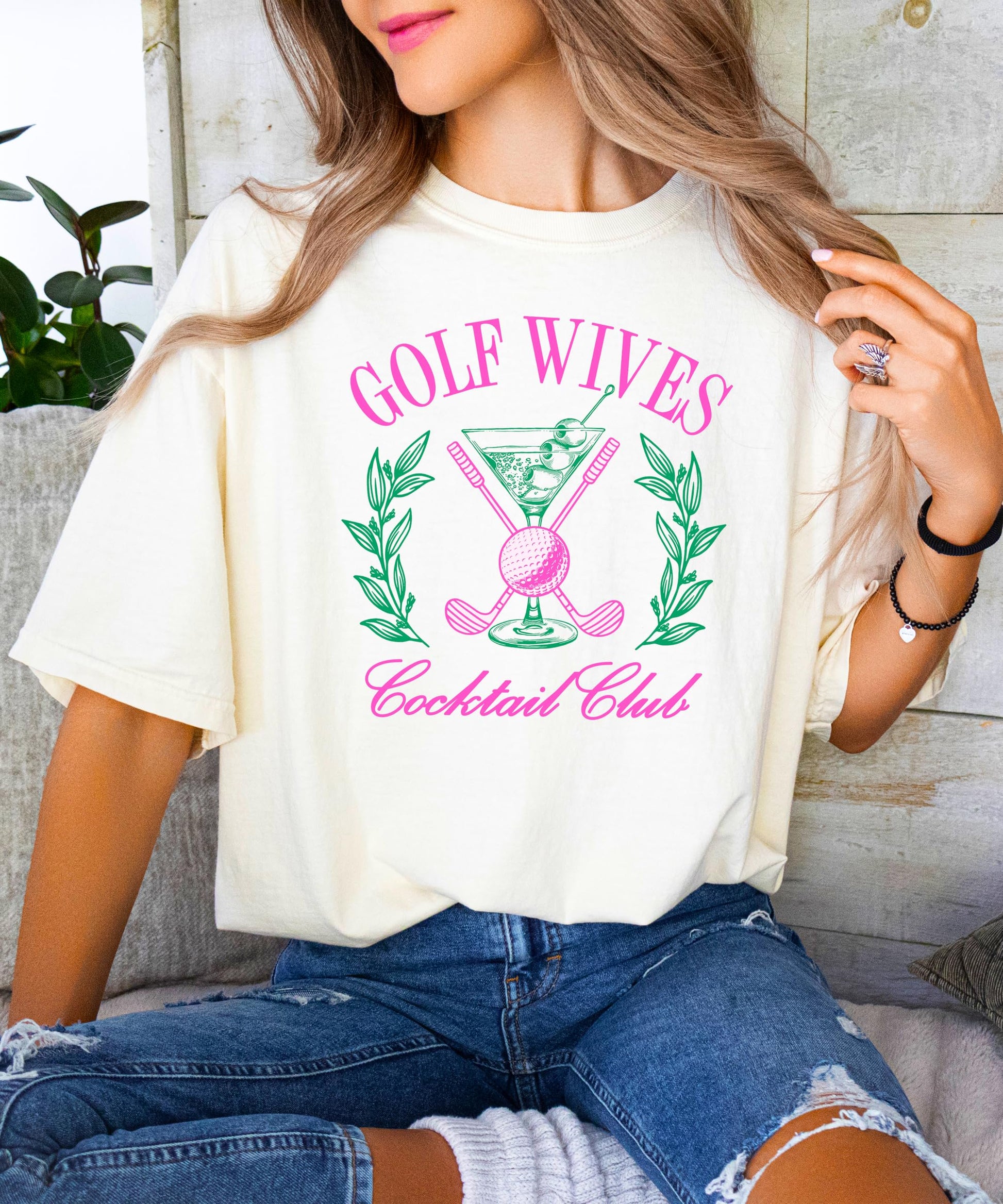 Close-up of Golf Wives Cocktail Club shirt design showing dirty martini glass and crossed golf clubs print detail