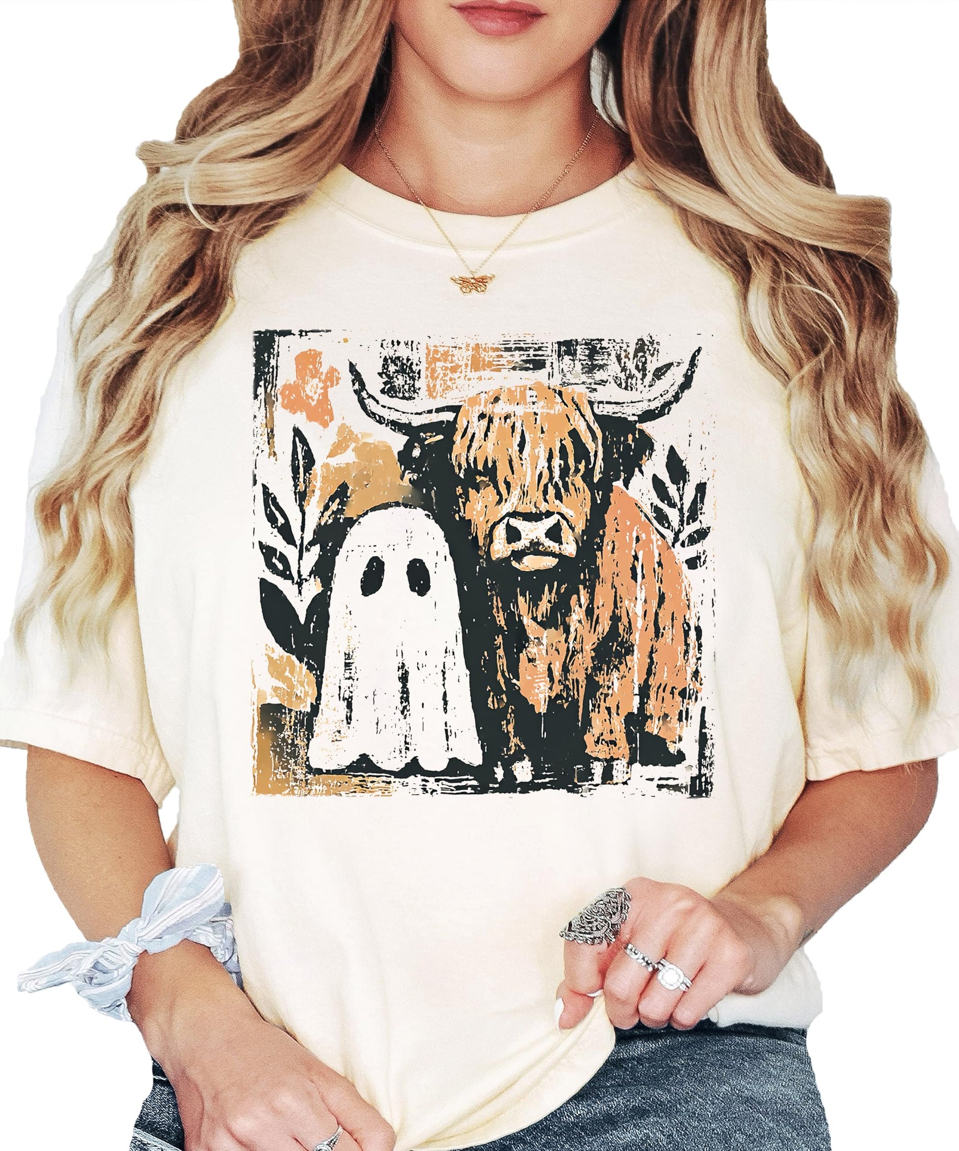 Women's ivory graphic tee featuring a cute ghost and highland cow Halloween design for fall