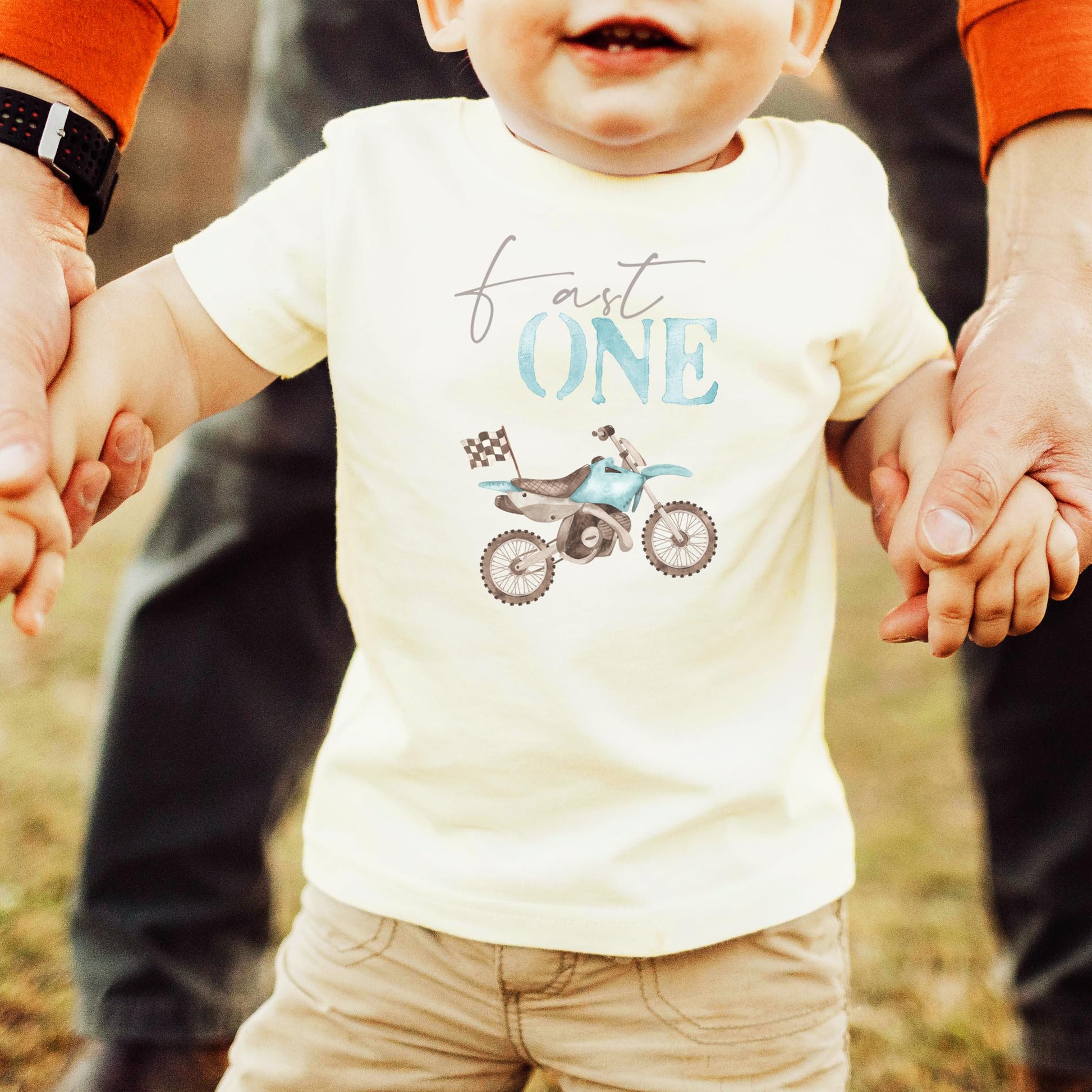 Close-up of blue dirt bike and One graphic print on boys 1st birthday tee