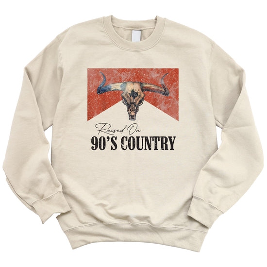 Close-up of distressed longhorn skull graphic with Raised On 90s Country text on white sweatshirt