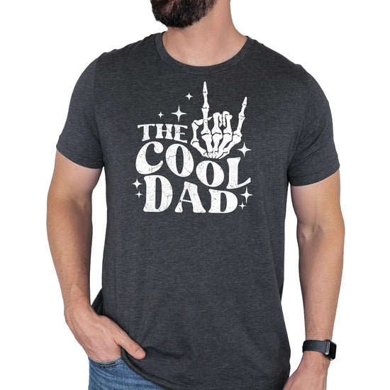 Front view of cool dad skeleton hand rock graphic t-shirt in black on male model